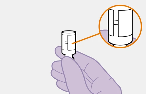A hand holding a white cylindrical medical device with a magnified detail in an orange circle showing a central slit