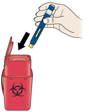 Una mano sostiene una pluma inyectora azul y amarilla y la está introduciendo en un recipiente rojo para residuos biológicos con símbolo de riesgo biológico
