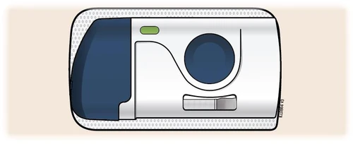 Dispositivo médico blanco con una sección azul oscuro a la izquierda, un botón verde arriba y un gran círculo azul a la derecha