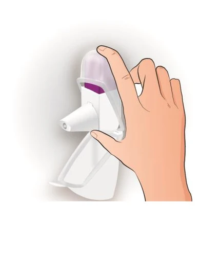 A hand holding a white medical device with a transparent cap showing purple contents inside