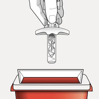 A hand holds a medical device with a spiral needle above a red sharps disposal container