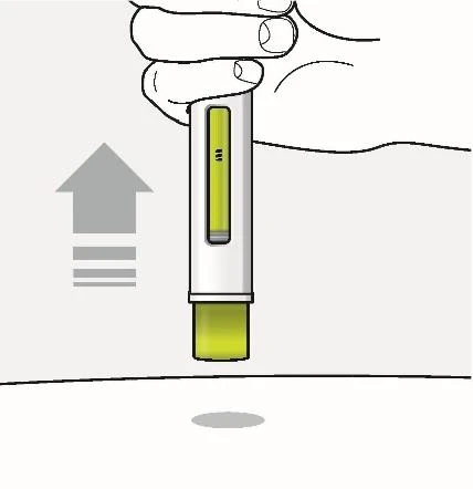 A hand holds a white and green medical device oriented vertically upward
