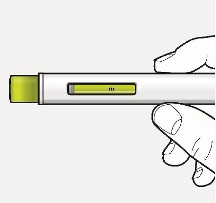 Two hands holding horizontally a white medical device with a small rectangular window showing light green liquid