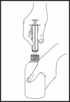 Una mano sostiene verticalmente una jeringa mientras la