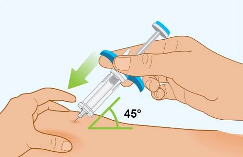 A hand holding a syringe ready to insert it into the