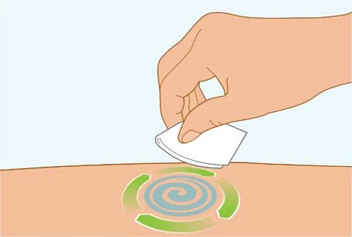 A hand applying a white bandage to the skin over a circular mark with a blue spiral and rotating green arrows