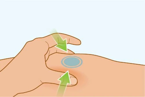 A hand applying a circular grey bandage to the body skin with two green arrows indicating downward pressure movement