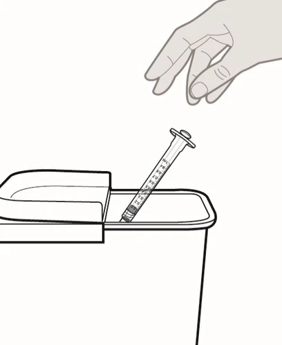 Una mano que suelta una jeringa usada en el