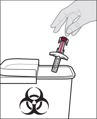 Una mano inserta un dispositivo médico con líquido rosa en un contenedor para residuos biológicos marcado con el símbolo de riesgo biológico