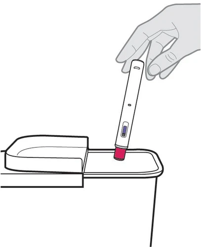 Una mano sostiene un dispositivo médico blanco con forma de pluma con punta roja apoyado sobre una superficie plana blanca