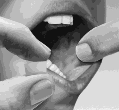 Primer plano en blanco y negro de una persona usando los dedos para retirar los labios hacia atrás y mostrar los dientes y la lengua