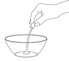 Una mano sostiene un frasco y vierte un líquido transparente