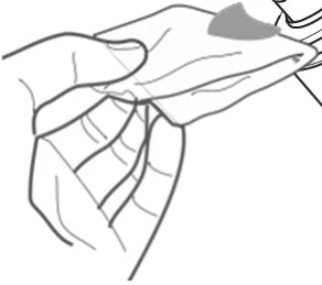 A hand holding and opening a small plastic pouch or wrapper to carefully remove its contents