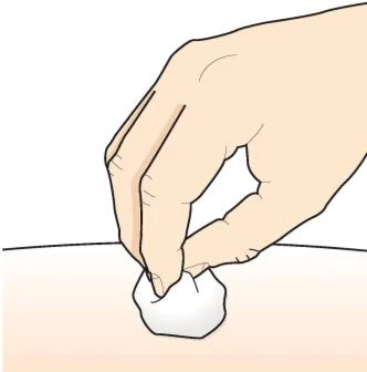 A hand gently pressing a white cotton ball onto the surface of light skin