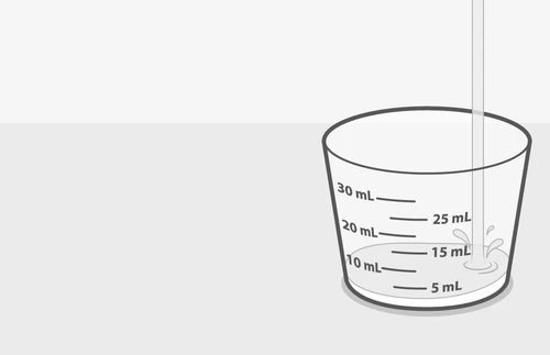 A graduated glass with markings at 5, 10, 15, 20, 25, and 30 ml while liquid is being poured into it