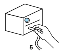 Una mano inserta un dispositivo con forma de pluma en una ranura de un recipiente blanco con una pequeña ventanilla circular azul