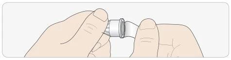 Dos manos sujetan y giran una pluma inyectora para retirar o colocar la tapa protectora blanca