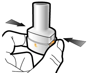 Two hands squeezing a white cylindrical medical device with gray arrows indicating lateral inward pressure movement