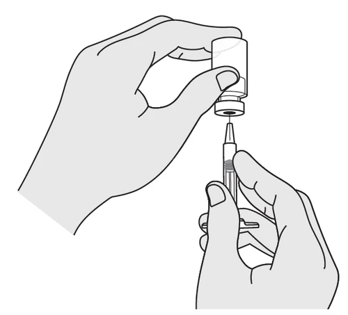 Two hands preparing the medication: one holding a glass vial while the other