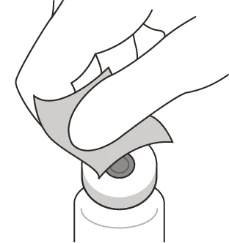 Una mano levanta suavemente un pequeño trozo de cinta adhesiva o esparadrapo aplicado sobre un dispositivo médico circular blanco