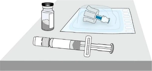 Frasco de vidrio con tapón negro, jeringa con líquido gris y envase de jeringas precargadas sobre una superficie plana gris