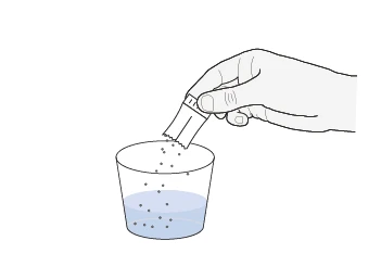 Una mano sostiene una bolsita abierta sobre un vaso que contiene un líquido azul mientras el polvo cae hacia