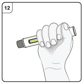 Una mano sostiene con fuerza un dispositivo médico en forma de pluma con un depósito transparente que contiene líquido amarillo y el número 12 en la parte superior