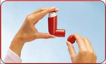 Due mani tengono un inalatore rosso, una mano regge il corpo del dispositivo mentre l'altra svita un piccolo tappo rotondo nella parte superiore