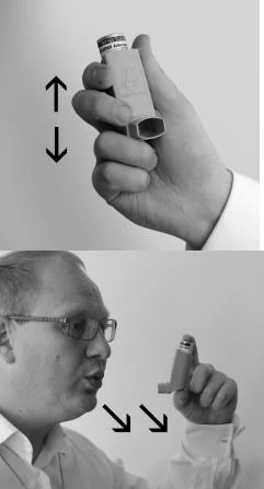 Composición en blanco y negro que muestra una mano sosteniendo el inhalador en posición vertical y a un hombre con gafas insuflando aire en el dispositivo