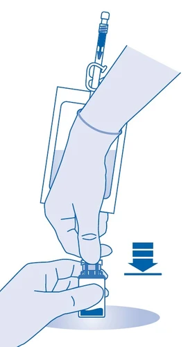 Mano con guante sostiene un vial, mientras que la otra mano presiona el émbolo de la jeringa hacia abajo para extraer líquido del recipiente con el fin de preparar el medicamento