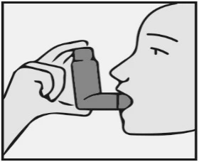 A profile view of a person holding the inhaler at the mouth to take a dose of medication, hand gripping the device housing at an angle
