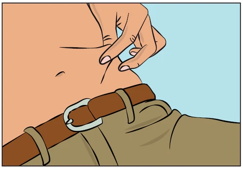 A hand gently lifting a skin fold on the abdomen of a person wearing pants with a brown leather belt on a light blue background
