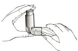 Two hands holding a vertical applicator, one hand stabilizing the device at the top while the other presses the lower part of the mechanism to deliver medication