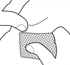 Mano con dita che applicano un cerotto quadrato con motivo a rete sulla pelle, preparando la zona per l'applicazione del farmaco