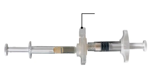 A transparent syringe with a plunger and a white cap in the middle, placed horizontally on a white background with a black arrow pointing to the upper part of the device