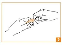 Two hands holding and gently tearing open a small orange package or sachet to remove its contents