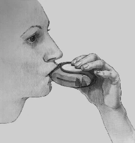 Profile of a woman holding an inhaler to her mouth, preparing to take a dose of medication using an inhalation device