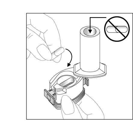Hand holding a capsule being inserted into an opening in the white medical device, with a prohibition symbol next to another opening indicating not to insert the capsule there