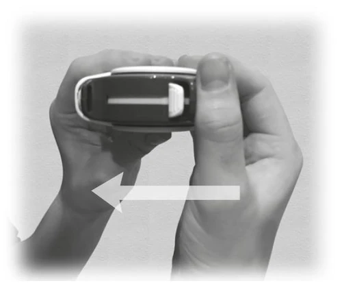 Two hands holding a black automatic injector with a white arrow indicating movement to the left, against a light background