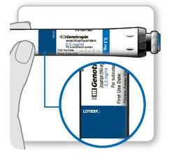 Mano che tiene una fiala bianca del farmaco Genotropin 5,3 mg/ml, con un ingrandimento circolare che mostra l'etichetta con le diciture LOT e EXP