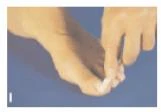 Mani che tengono e massaggiando delicatamente un piede, focalizzate sulle dita e sulla pianta del piede su uno sfondo blu