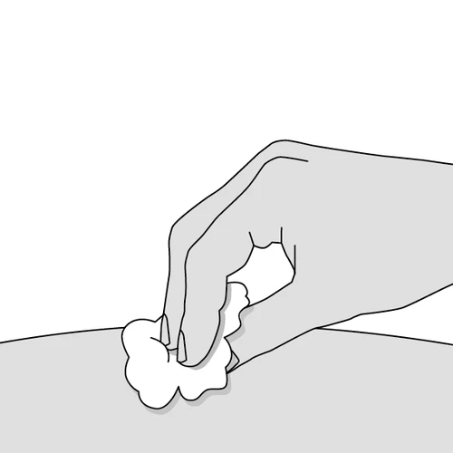 Hand holding a white cotton ball or gauze pad and applying it to a smooth body surface to clean the skin
