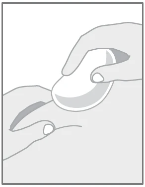 Two hands holding a white, oval capsule or tablet, preparing or administering it against a light background