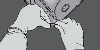 Dos manos con guantes sujetan y separan suavemente una parte del envase o protección médica para abrir el producto