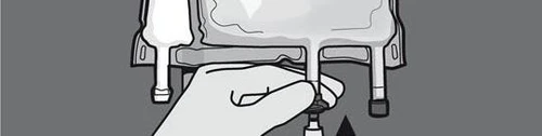 Hand holding and pressing the plunger of a syringe inside a package containing medication vials on a gray background