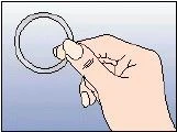 La mano derecha sostiene con los dedos un anillo delgado y circular o junta tórica sobre un fondo azul claro