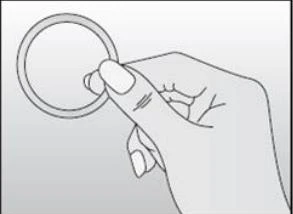 Right hand holding a small round ring-shaped object with fingers against a bright background