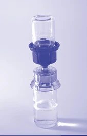 Fiala di vetro trasparente con liquido incolore collegata all'elemento superiore del dispenser tramite un raccordo di plastica scura su sfondo chiaro