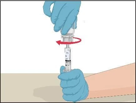 Mani con guanti blu tengono una siringa, la mano superiore compie un movimento rotatorio indicato da una freccia rossa intorno al tappo