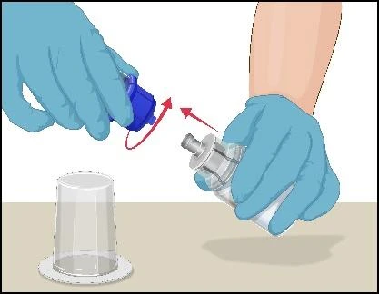 Mani con guanti medici blu svitano un tappo blu da un contenitore trasparente di farmaco posizionato su un piano chiaro